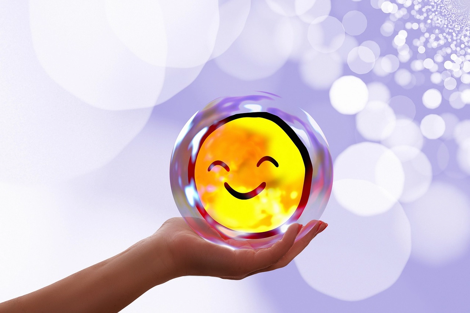Mindtrail - Coaching und Mentoring - Eine Hand hält eine leuchtende, transparente Kugel, die ein helles gelbes Smiley-Emoji enthält, vor einem verschwommenen Hintergrund aus violetten und weißen Lichtern.
